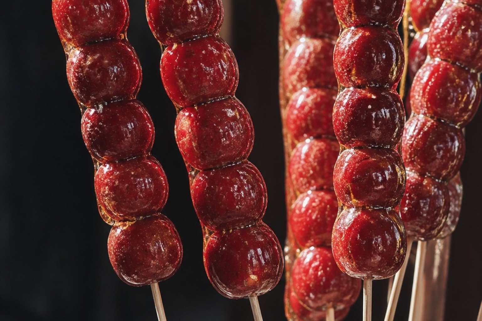 Glossy red tanghulu fruit skewers displayed upright.