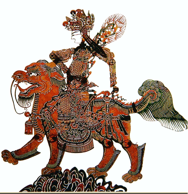 An intricately carved red, black, and gold Chinese shadow-puppet figure riding a stylized tiger-like creature.